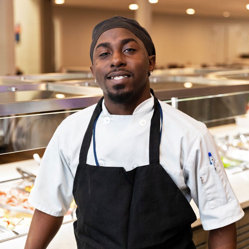 Employee smiling in front of serving line